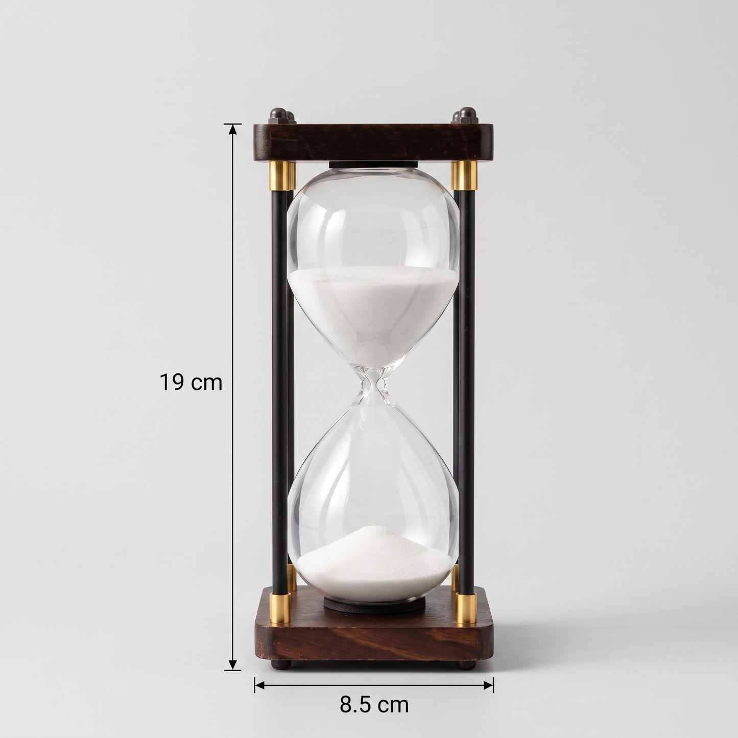 Ampulheta decorativa de 30 minutos com areia branca em fundo neutro e indicação de medidas de 19 cm de altura e 8.5 cm de base Casa Vértice.