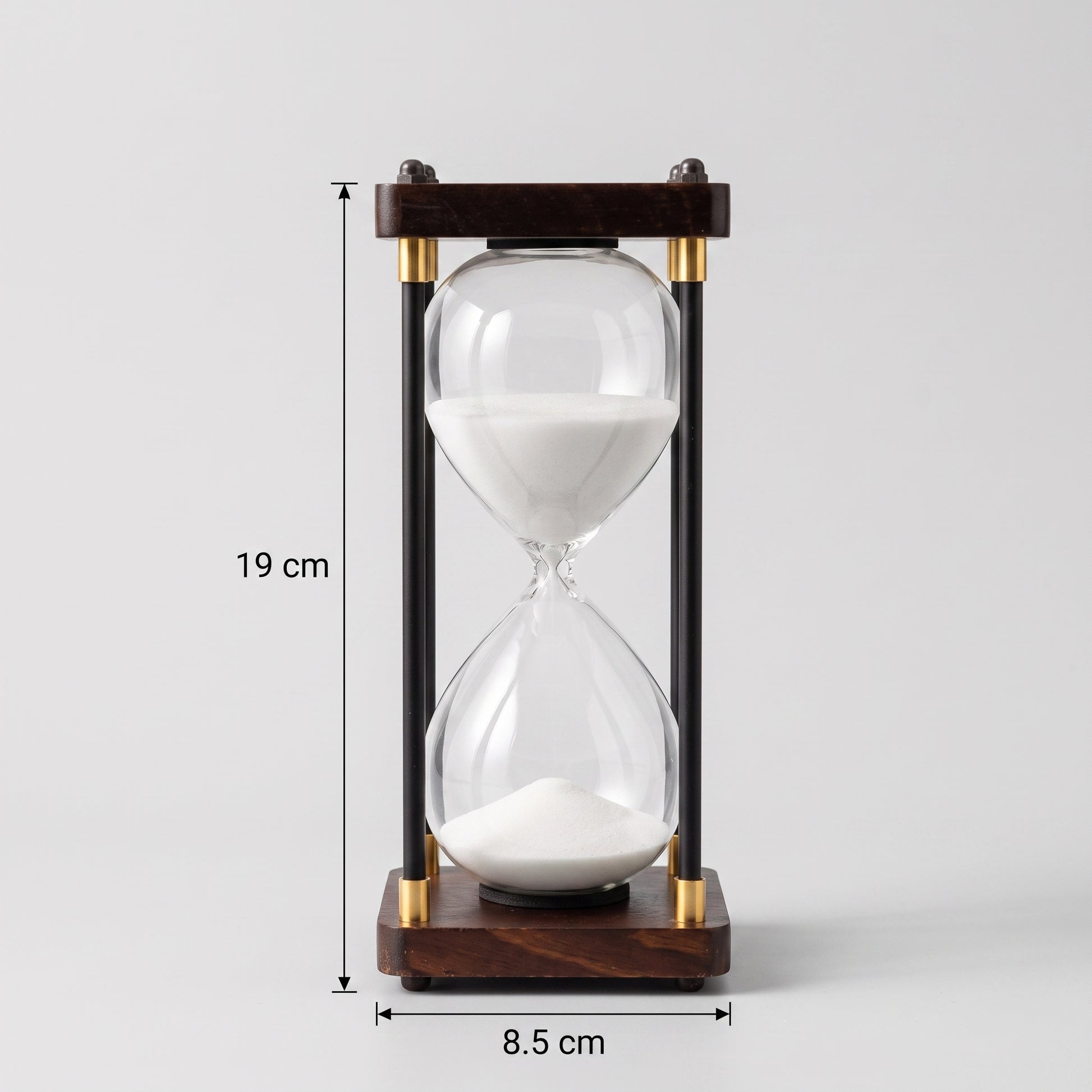 Ampulheta decorativa de 30 minutos com areia branca em fundo neutro e indicação de medidas de 19 cm de altura e 8.5 cm de base Casa Vértice.