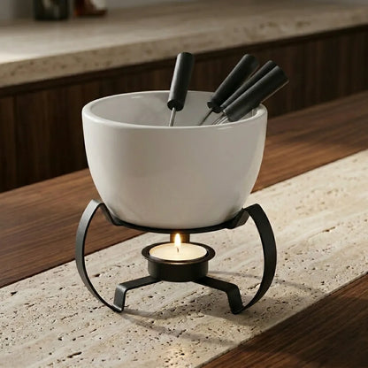 Aparelho de fondue em cerâmica branca mate com suporte de ferro curly sobre mármore travertino e nogueira, curadoria Casa Vértice.