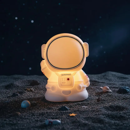 Luminária astronauta Astro Touch em cenário lúdico simulando superfície lunar com estrelas.