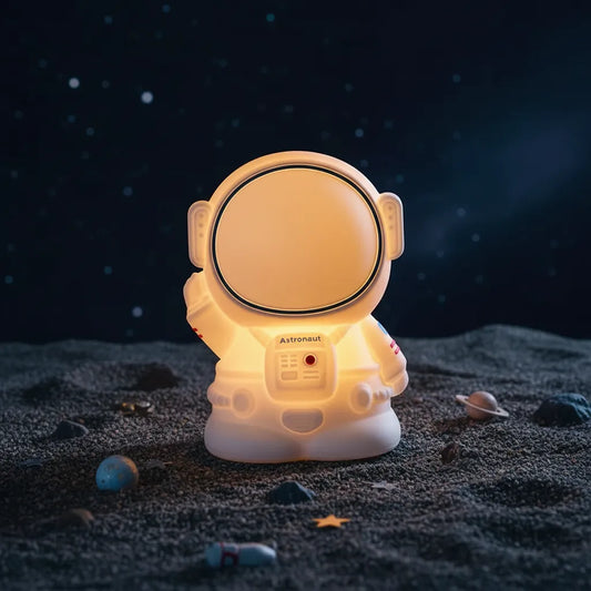 Luminária astronauta Astro Touch em cenário lúdico simulando superfície lunar com estrelas.