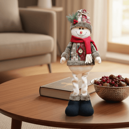 boneco de neve decorativo sobre mesa com cachecol vermelho