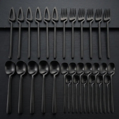 Faqueiro completo de 32 peças preto fosco organizado para servir 8 pessoas em mesa de luxo.