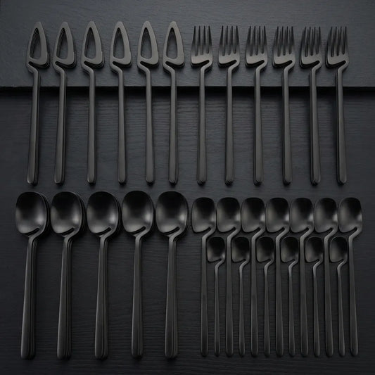Faqueiro completo de 32 peças preto fosco organizado para servir 8 pessoas em mesa de luxo.