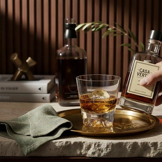 Composição de mesa posta sofisticada com copo de whisky Monte Fuji em ambiente de luxo.