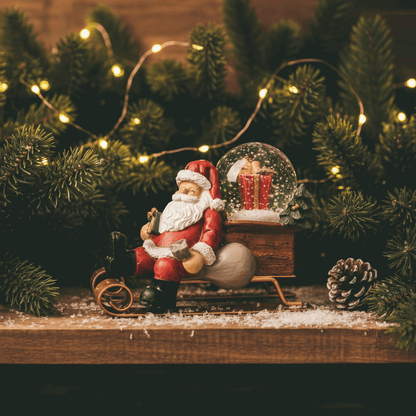 close da estatueta Papai Noel no trenó em resina com globo de neve