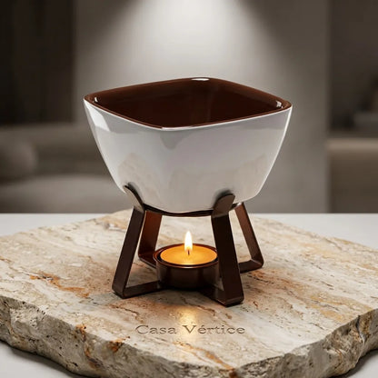 Aparelho de fondue individual em cerâmica branca com design quadrado sobre bloco de mármore travertino assinado Casa Vértice.