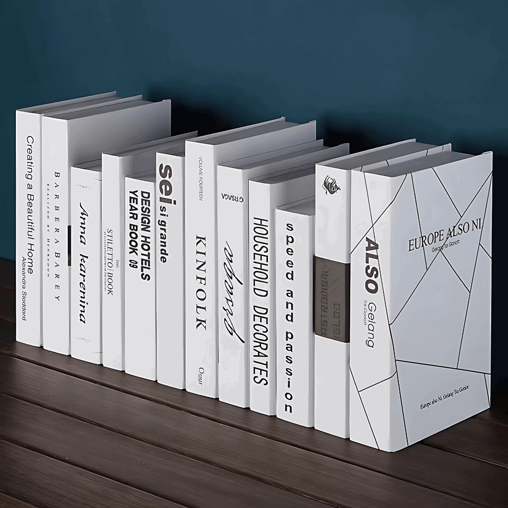 Livros falsos decorativos branco e cinza com tipografia moderna e acabamento fosco para styling editorial.