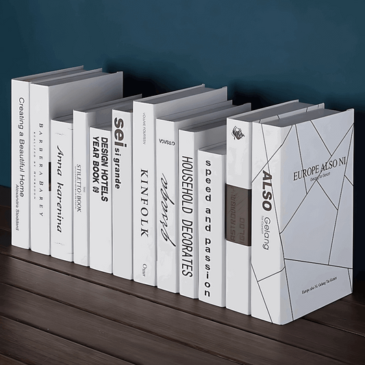 Livros falsos decorativos branco e cinza com tipografia moderna e acabamento fosco para styling editorial.