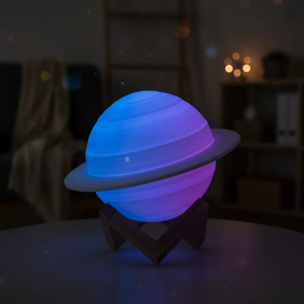 Luminária de mesa planeta Saturno brilhando em azul e roxo com efeito galáxia.