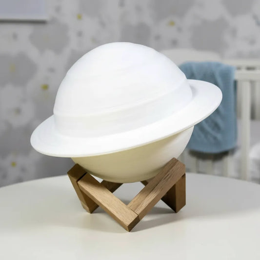 Luminária Saturno 3D desligada sobre base de madeira em quarto infantil moderno.